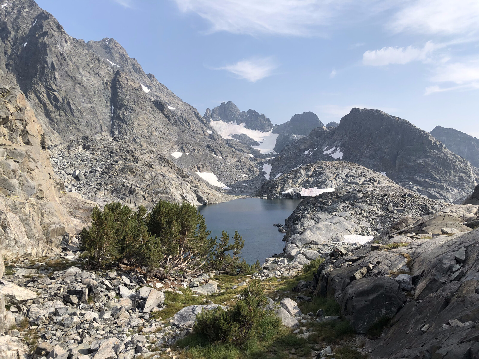 Alpine lake between jagged peaks with sparse vegetation